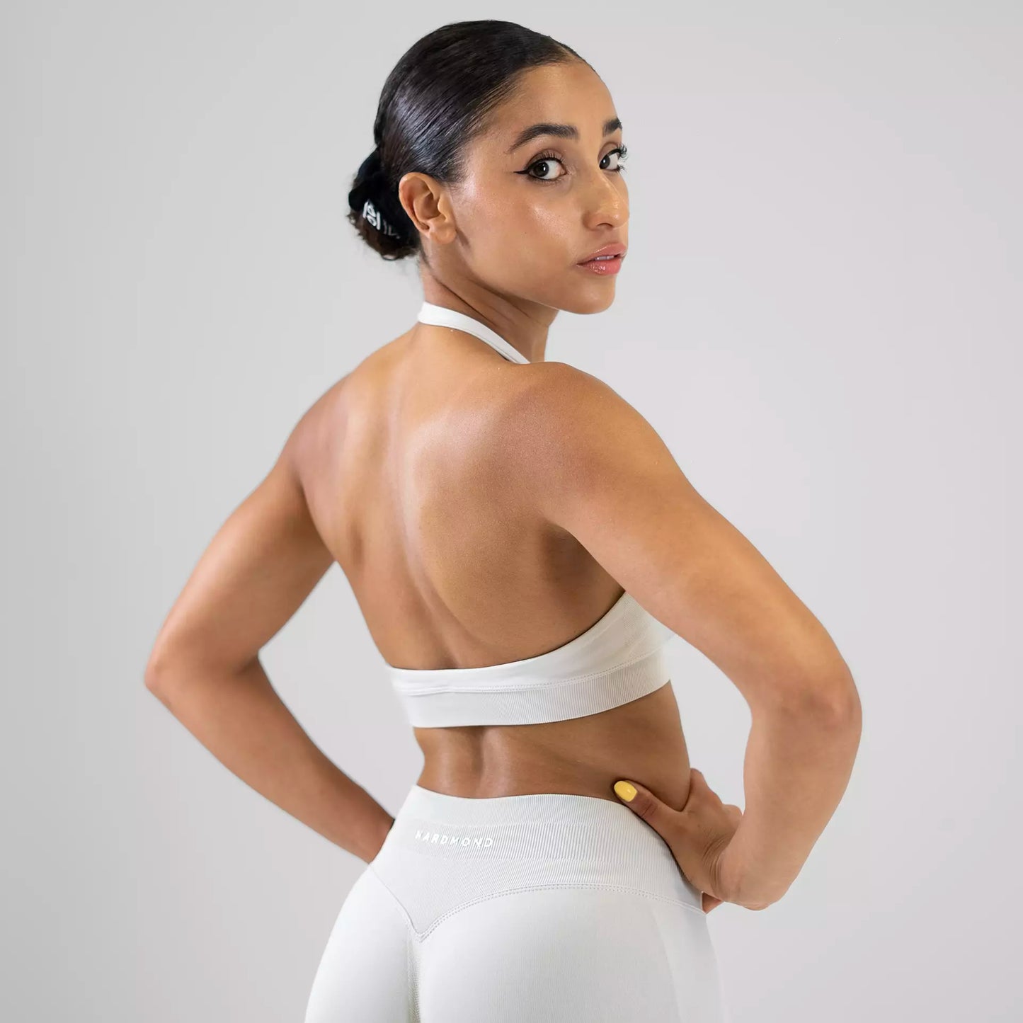 Side view showing open back detail of beige sports bra
